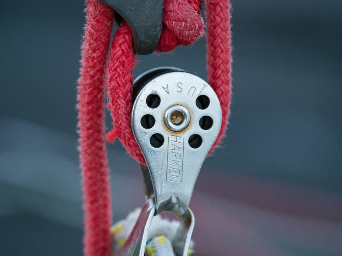 Beginner comparing indoor rock climbing gear for beginners at a local climbing shop with price tags visible