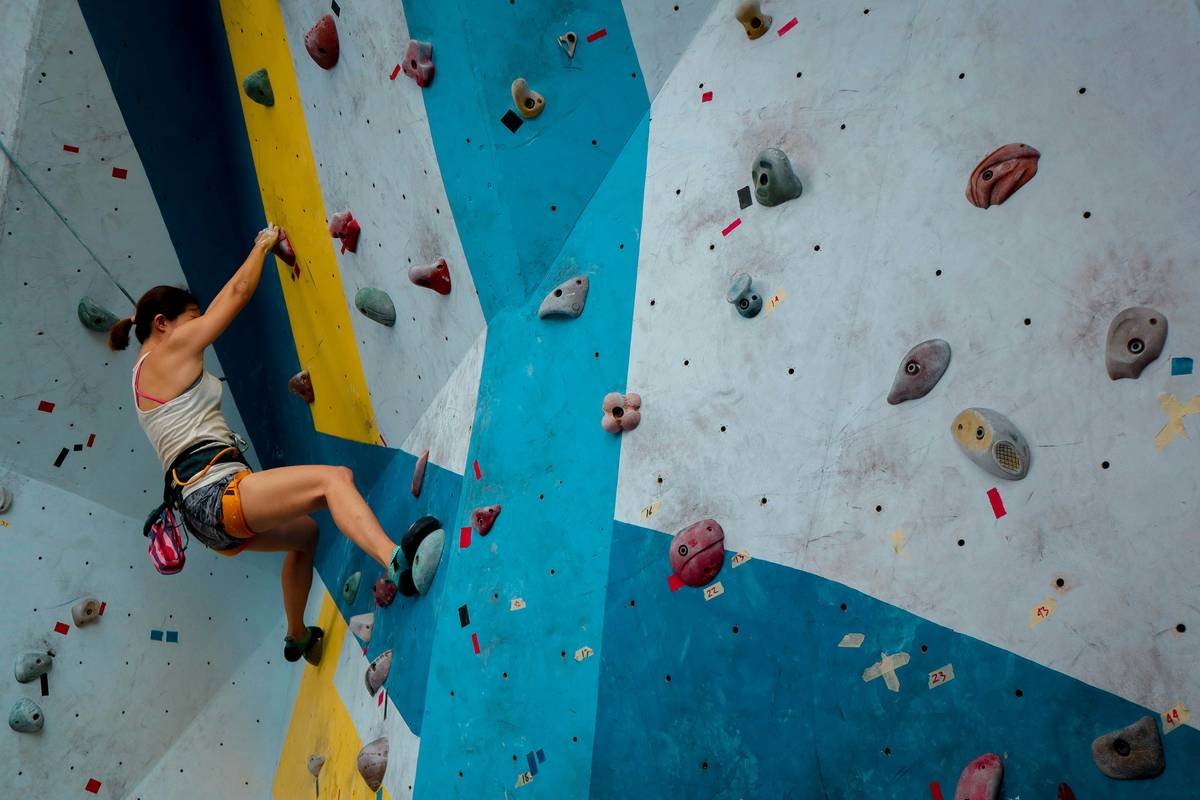 Climber demonstrating physical benefits of climbing on outdoor rock face